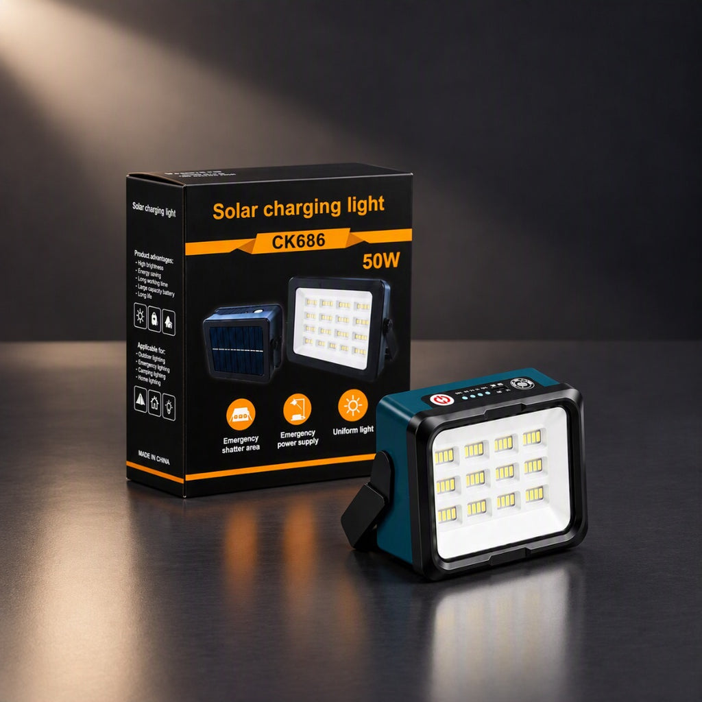 A teal and black solar charging light with a white LED panel is shown next to its black retail box on a dark reflective surface. The box displays the text 'Solar charging light', model 'CK686', and '50W'.