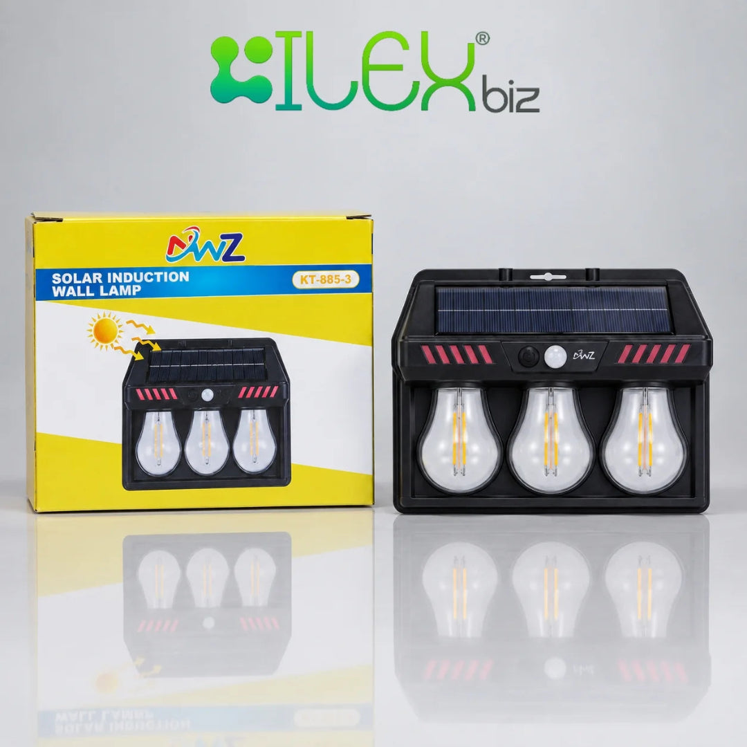 A solar induction wall lamp shown next to its yellow and white retail box, with the brand name ILEX biz displayed at the top. The lamp is black with a built-in solar panel on top and three clear light bulbs inside, set against a clean white background with a reflective surface.