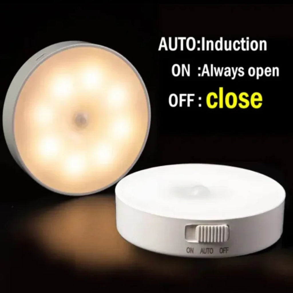 A small round LED light switch device shown on a black background, with one view illuminated warm white and one view off, showing a side switch. Text on the image explains the modes: AUTO: Induction, ON: Always open, OFF: close.