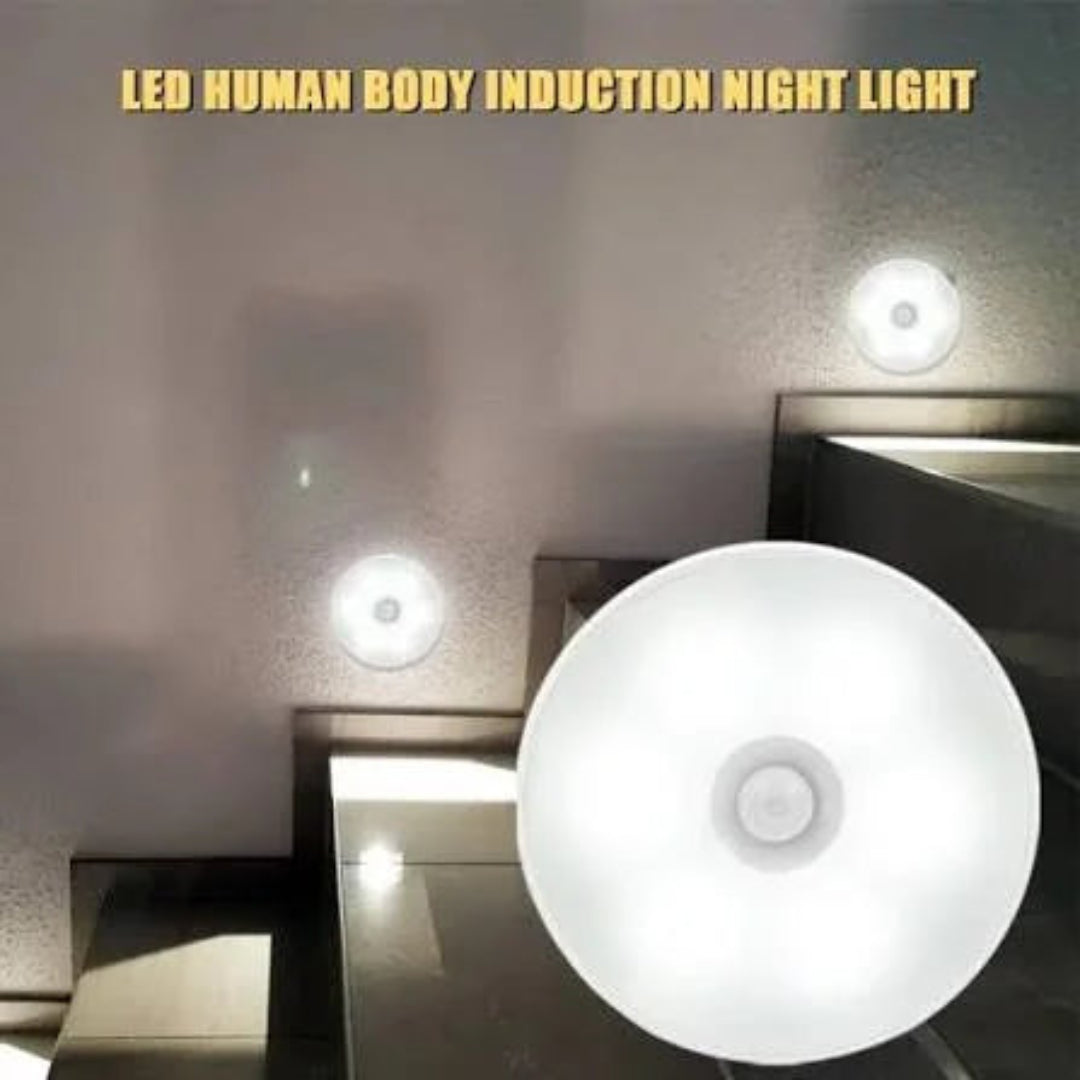 A white circular LED night light shown in a close-up, with smaller views of the light mounted on a wall in a bathroom setting. Text at the top reads 'LED HUMAN BODY INDUCTION NIGHT LIGHT'.