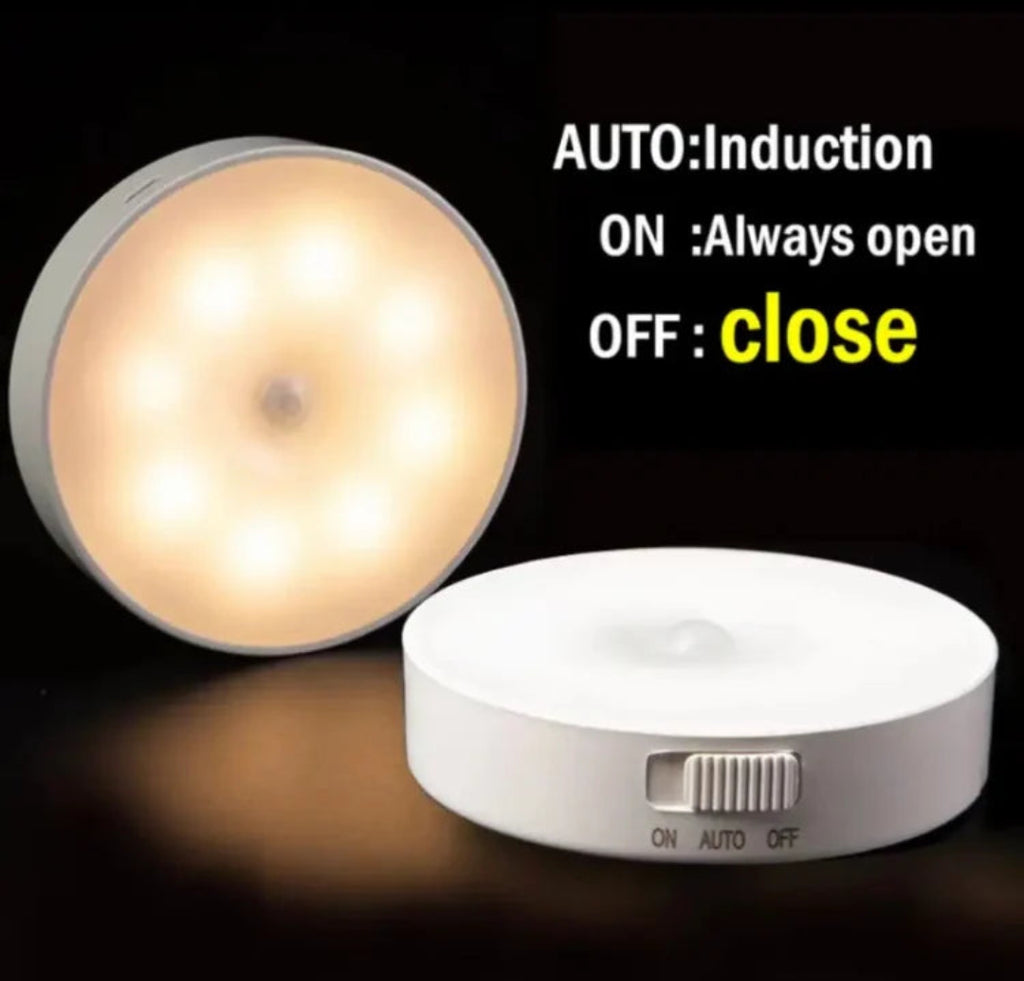 A small round LED light switch device shown on a black background, with one view illuminated warm white and one view off, showing a side switch. Text on the image explains the modes: AUTO: Induction, ON: Always open, OFF: close.
