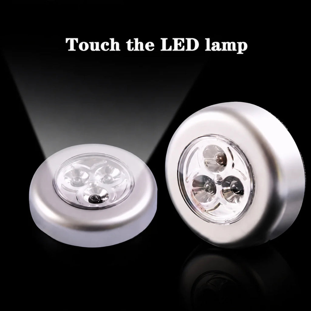 Two round silver LED night lights on a black reflective background