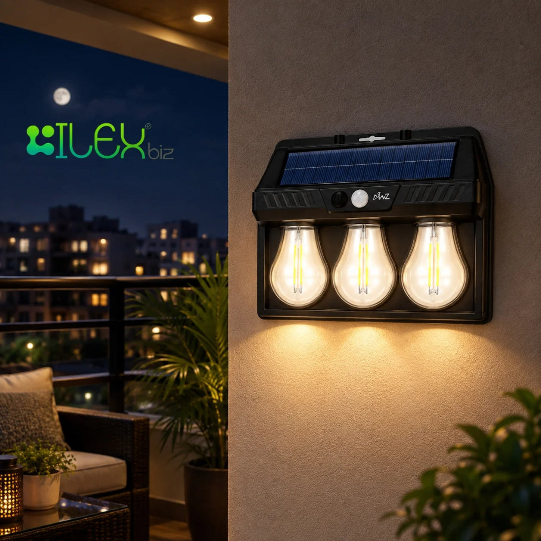 A wall-mounted three-light solar outdoor fixture with a black housing, integrated solar panel, and glowing bulb-shaped lights, shown mounted on a beige wall beside a balcony at night. The brand name ILEX biz appears in the upper left.