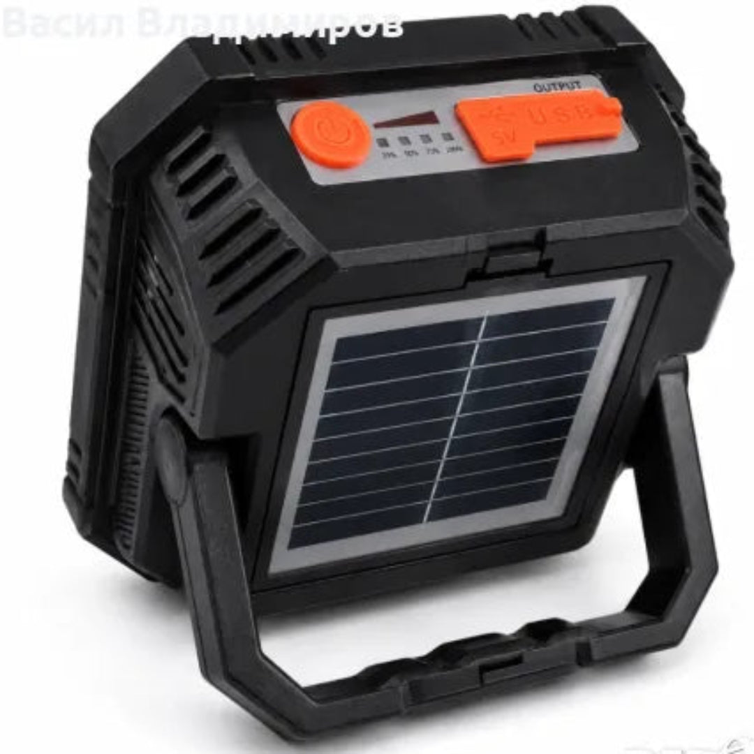 A rugged black solar power bank with a built-in handle, featuring a front solar panel and orange power buttons on top, shown on a white background.
